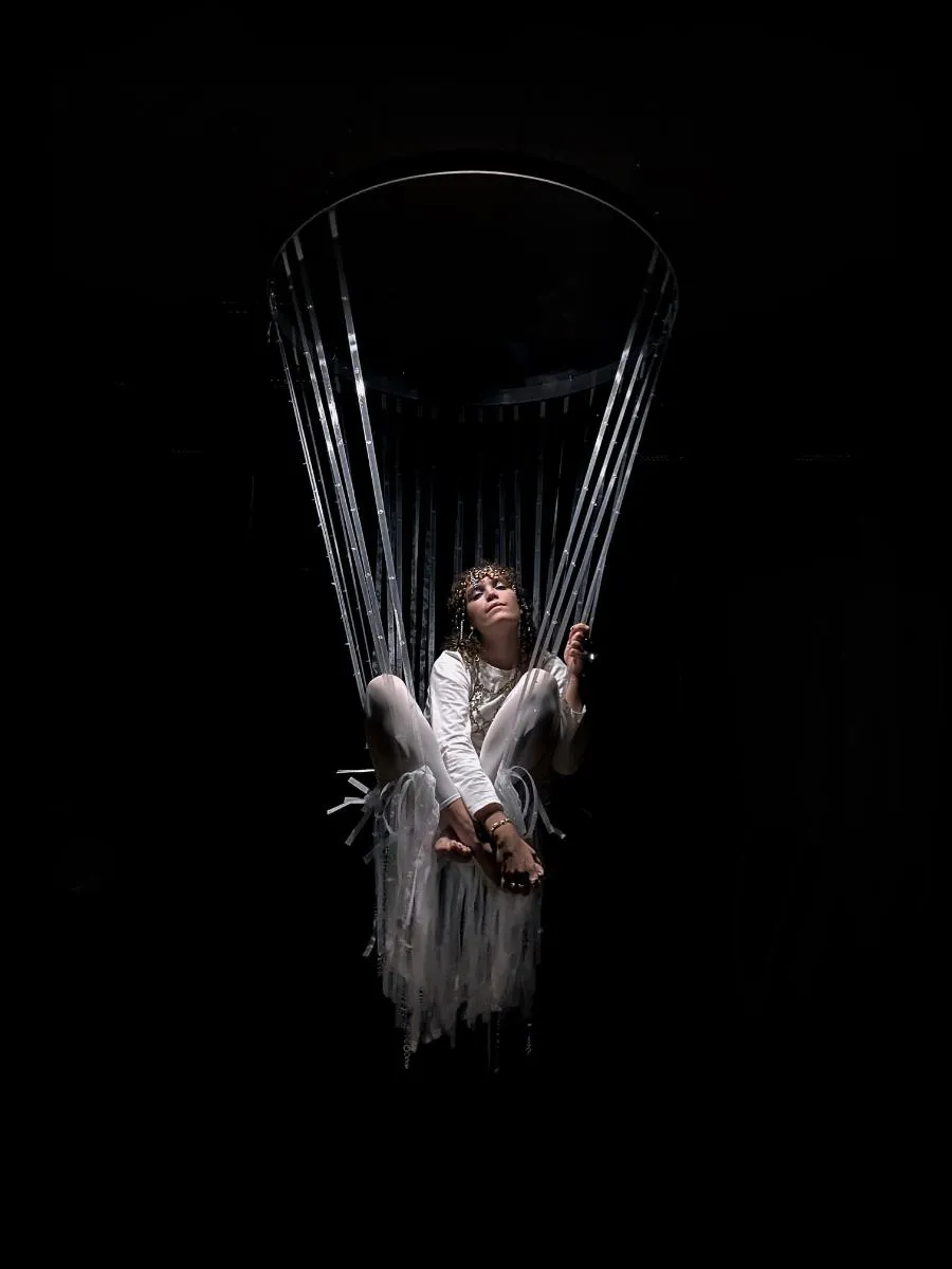 Hanging chair with a girl sitting in it. Photo. 