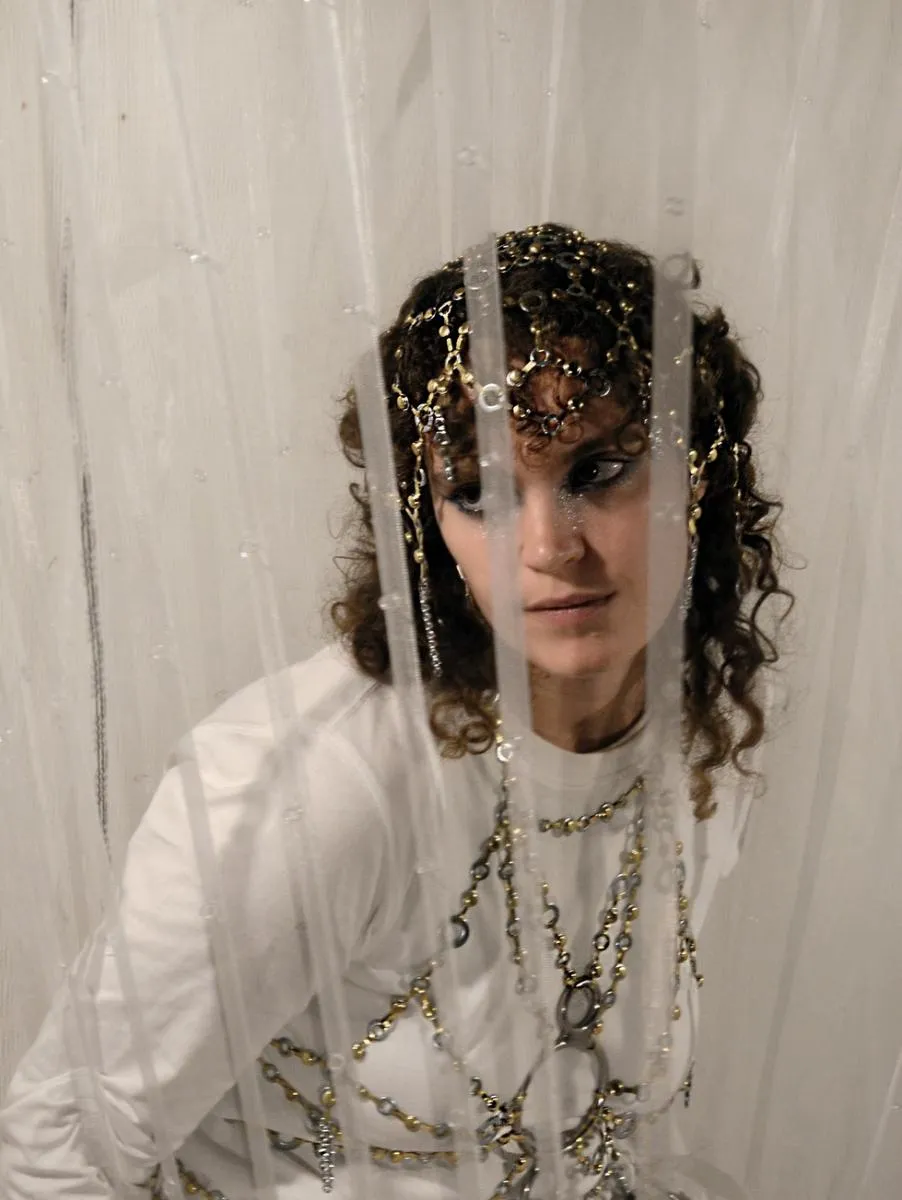 A girl in a white dress and jewellery. Photo. 