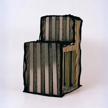 Chair covered with a black translucent fabric. Photo.