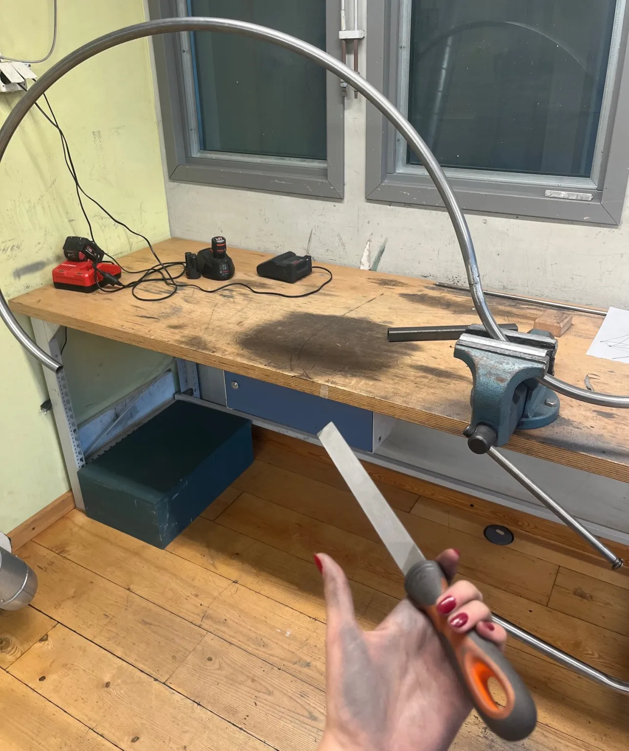 Woman's hand holding a file and metal furniture in back. Photo. 