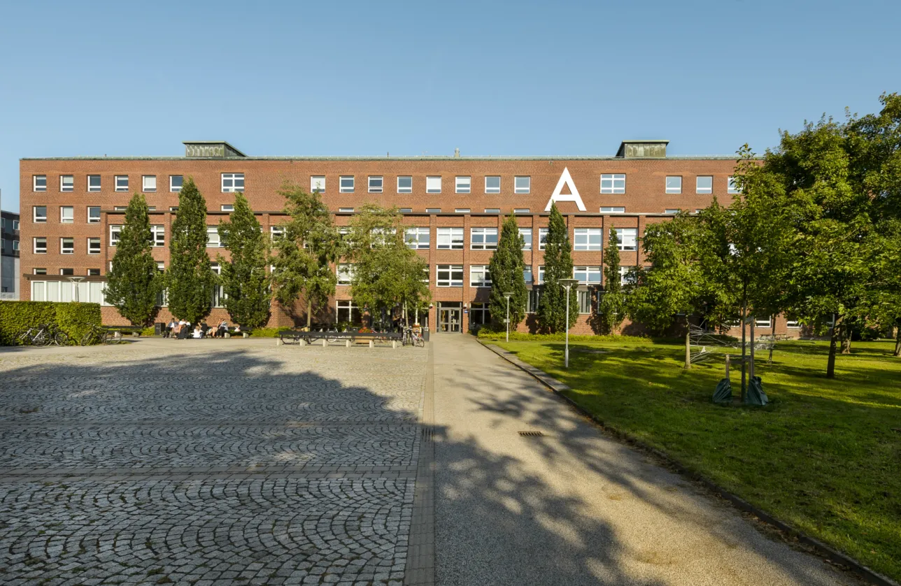Facade av a brickbuilding with trees infront. Photo. 