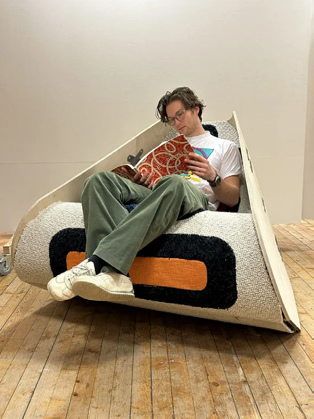 Man sitting in triangular chair. Photo.