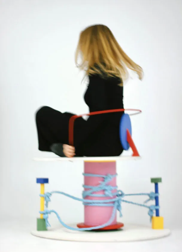 Girl sitting on a spinning colorful chair. Photo.
