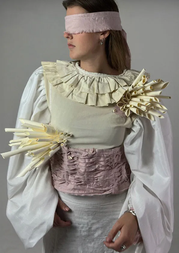 Blindfolded woman wearing white and pink top. Photo.